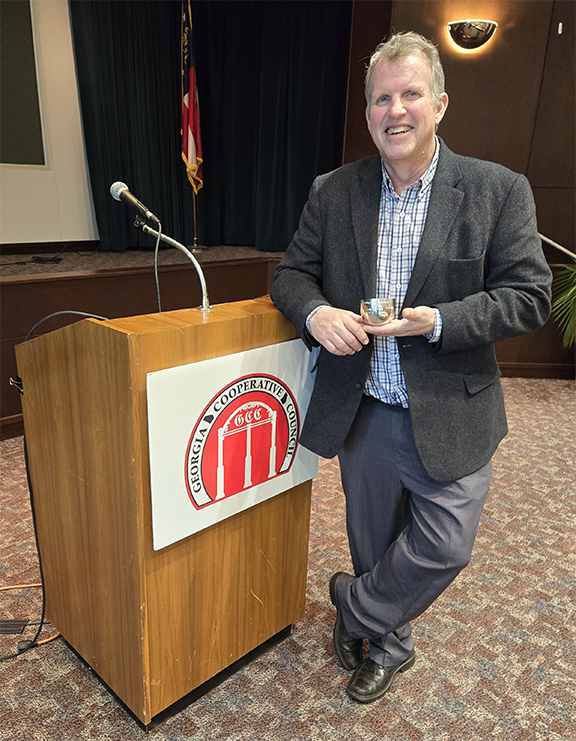 Scott Fuss stands with award