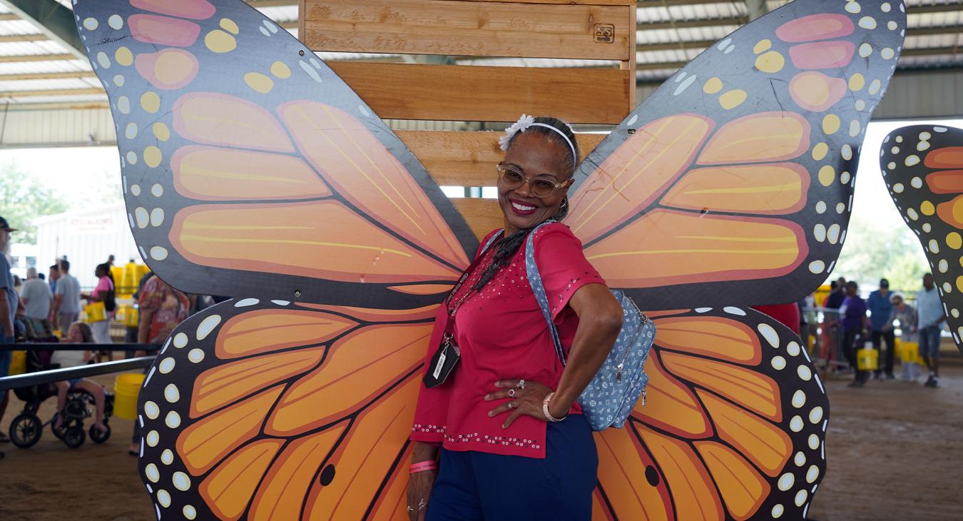 Member poses in front of Butterfly display