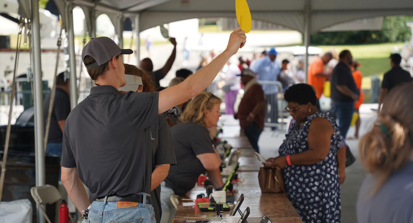 Employees assist members with registration