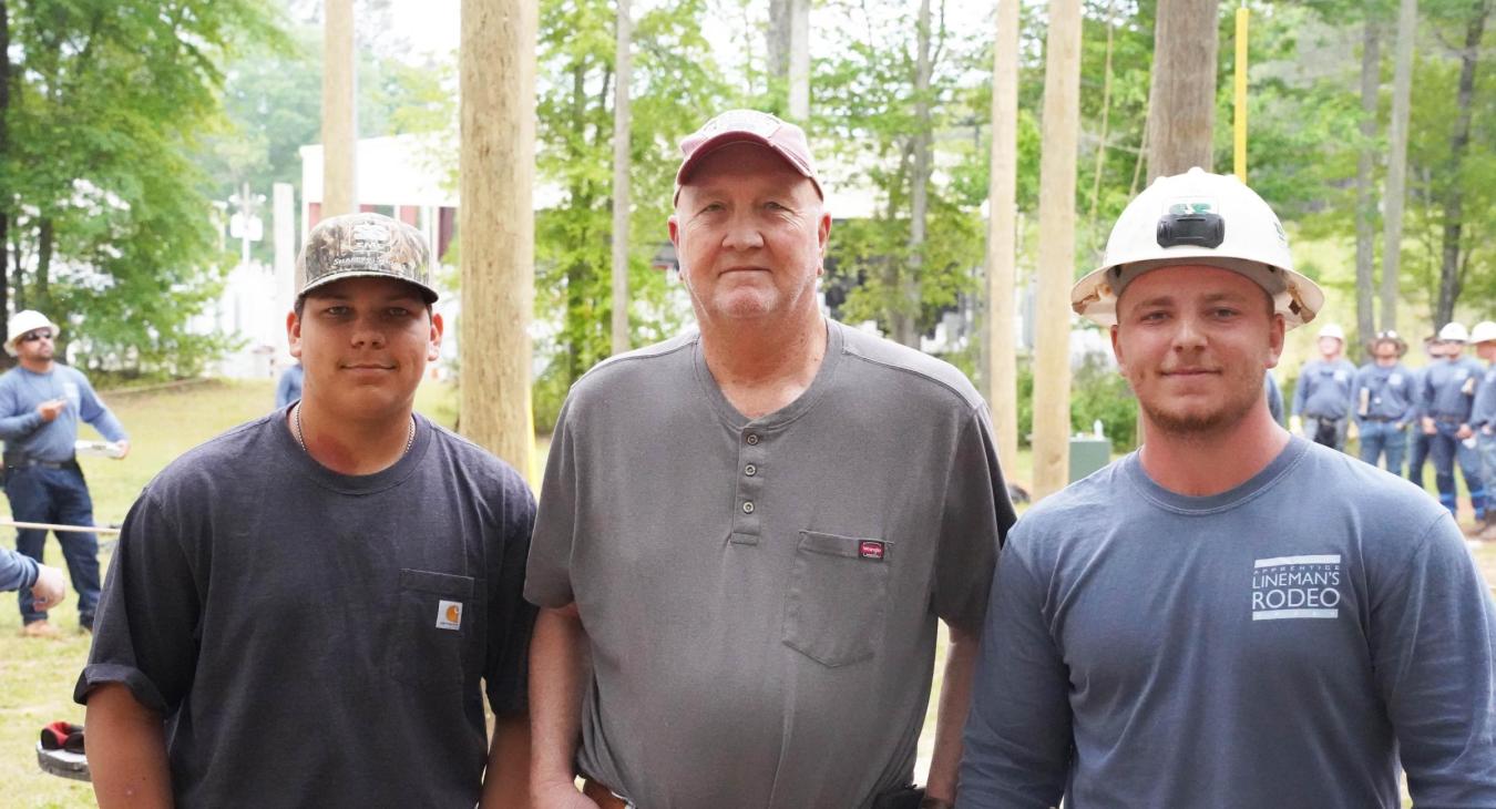 Engineering Youth Apprentice Walker Allen (left) stands with his grandfather and retired SSEMC lineman, Kyle McDonald, and his brother Jackson Allen (right), who is an Apprentice Lineman and former Engineering Youth Apprentice.